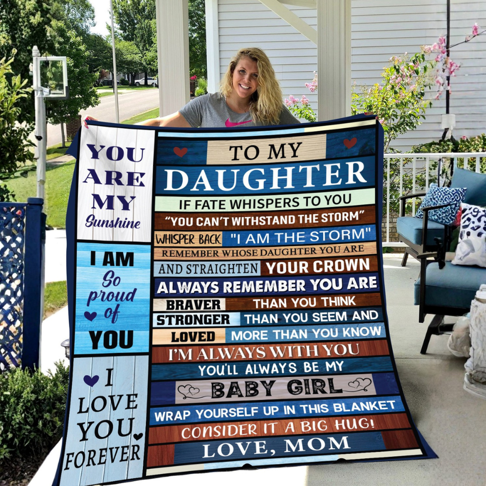 "Smiling mother proudly holding a large ‘To My Daughter’ blanket in a bright outdoor garden setting."